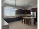 Large kitchen with dark cabinets, stainless steel appliances, and a breakfast bar island at 9734 S 182Nd Dr, Goodyear, AZ 85338