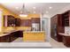 Bright kitchen features dark cabinetry, a stainless steel refrigerator, a central island, and warm yellow walls at 9734 S 182Nd Dr, Goodyear, AZ 85338