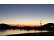 Gorgeous sunset at the community lake with birds, serene waterfront view, and distant mountain views at 9734 S 182Nd Dr, Goodyear, AZ 85338