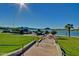Pathway leading down to a scenic lake view with a gazebo and grassy area with palm trees at 9734 S 182Nd Dr, Goodyear, AZ 85338