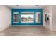 Bright living room featuring wood-look floors, blue accent wall, and view of backyard pool at 9734 S 182Nd Dr, Goodyear, AZ 85338