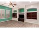 Cozy living room with a ceiling fan and built-in shelving with dark wood cabinets at 9734 S 182Nd Dr, Goodyear, AZ 85338