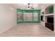 Spacious living room with light wood floors, modern ceiling fan, and a stylish green accent wall with bright windows at 9734 S 182Nd Dr, Goodyear, AZ 85338