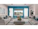 Bright living room featuring stylish decor, wood-look floors, and view of backyard pool at 9734 S 182Nd Dr, Goodyear, AZ 85338