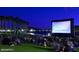 Outdoor movie night with lawn seating, large screen, and lake views, perfect for community entertainment at 9734 S 182Nd Dr, Goodyear, AZ 85338