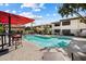 Community pool with lounge chairs, umbrellas, and lush landscaping at 9990 N Scottsdale Rd # 1006, Paradise Valley, AZ 85253