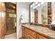 Bathroom featuring wood cabinetry, granite countertop, mosaic shower, and glass door at 10798 E Hedgehog Pl, Scottsdale, AZ 85262