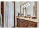 Bathroom vanity with granite countertop, wood cabinetry, and decorative mirror at 10798 E Hedgehog Pl, Scottsdale, AZ 85262