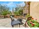 Cozy outdoor seating around a stone fireplace with vibrant flowers at 10798 E Hedgehog Pl, Scottsdale, AZ 85262