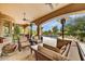 Inviting covered patio features ceiling fans, heaters, comfortable seating, and a view of the pool at 10798 E Hedgehog Pl, Scottsdale, AZ 85262