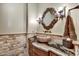 Charming powder room with stone vessel sink and decorative mirror at 10798 E Hedgehog Pl, Scottsdale, AZ 85262