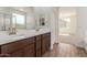 Bathroom featuring a double sink vanity with wood cabinets and tile flooring adjacent to a bedroom at 1187 E Ridgerock St, Casa Grande, AZ 85122