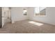 Sunlit bedroom with neutral carpet, bright white walls, and a view into an attached room at 1187 E Ridgerock St, Casa Grande, AZ 85122