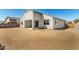 This is a view of a home's rear exterior, featuring neutral paint, covered patio, and desert landscaping at 1191 E Ridgerock St, Casa Grande, AZ 85122