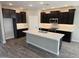 Modern kitchen with dark cabinetry, white quartz countertops, stainless steel appliances and gray wood flooring at 1191 E Ridgerock St, Casa Grande, AZ 85122