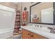 Well-lit bathroom featuring a white sink and cabinet, toilet, and shower with themed accents at 12752 W Junipero Dr, Sun City West, AZ 85375