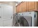 Functional laundry room with modern washer and dryer units, and ample cabinet space at 12752 W Junipero Dr, Sun City West, AZ 85375