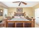 Relaxing main bedroom featuring a wooden bed frame, fan, and plenty of natural light at 12752 W Junipero Dr, Sun City West, AZ 85375