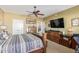 Spacious main bedroom featuring a ceiling fan, TV, and a convenient laundry area at 12752 W Junipero Dr, Sun City West, AZ 85375