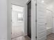 Hallway view to a bright bathroom, featuring wood-look floors and white bathtub at 13242 W Hackamore Dr, Peoria, AZ 85383