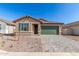 Charming single-story home featuring a green garage door, desert landscaping, and a paver driveway at 13242 W Hackamore Dr, Peoria, AZ 85383