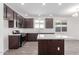 Kitchen with dark wood cabinets, white countertops and island, with modern appliances at 13242 W Hackamore Dr, Peoria, AZ 85383