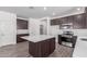 Spacious kitchen features an island, dark wood cabinets, and stainless steel appliances at 13242 W Hackamore Dr, Peoria, AZ 85383