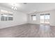 Bright and airy living room with wood-look flooring and sliding doors to the backyard at 13242 W Hackamore Dr, Peoria, AZ 85383