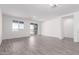 A modern living room with wood-look flooring, large windows and bright white walls at 13242 W Hackamore Dr, Peoria, AZ 85383