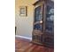 Dining room with an antique china cabinet, wooden floors, and a framed floral painting on the wall at 14009 N 30Th St, Phoenix, AZ 85032