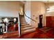 Entryway with stairs, hardwood floors, grandfather clock and view to the living room with fireplace at 14009 N 30Th St, Phoenix, AZ 85032