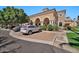 Exterior view of building with stone and stucco facade, arched entrances, and parking area at 14250 W Wigwam Blvd # 1326, Litchfield Park, AZ 85340