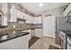 Clean kitchen featuring white cabinets, modern appliances, and a black mosaic tile backsplash at 14250 W Wigwam Blvd # 1326, Litchfield Park, AZ 85340