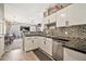 Well-lit kitchen featuring white cabinets, black countertops, and mosaic tile backsplash at 14250 W Wigwam Blvd # 1326, Litchfield Park, AZ 85340