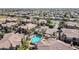 Aerial view of a community pool with a gazebo surrounded by well-maintained buildings and palm trees at 14250 W Wigwam Blvd # 1326, Litchfield Park, AZ 85340