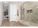 Spacious bathroom with a glass-enclosed shower, neutral tile, and a door leading to the bedroom at 1444 W Gail Rd, San Tan Valley, AZ 85144