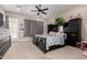 Comfortable bedroom featuring neutral carpeting, modern ceiling fan, and a stylish black bed frame at 1444 W Gail Rd, San Tan Valley, AZ 85144