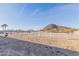 View of the fenced horse property with a backdrop of distant mountains and clear blue skies at 1444 W Gail Rd, San Tan Valley, AZ 85144