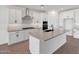 Modern kitchen features white cabinets, a large island, and stainless steel appliances at 14782 W El Cortez Pl, Surprise, AZ 85387