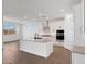 Bright, open kitchen featuring a central island, white cabinets, and modern stainless steel appliances at 14782 W El Cortez Pl, Surprise, AZ 85387