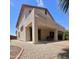 View of a well-kept back exterior showcasing a covered patio, desert landscaping, and security lighting at 15232 W Edgemont Ave, Goodyear, AZ 85395