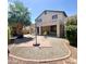 Landscaped backyard featuring covered patio, palm trees, decorative shrubs and a red brick walkway at 15232 W Edgemont Ave, Goodyear, AZ 85395