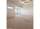 Bright and airy bedroom featuring neutral carpet, ceiling fan and multiple windows for ample natural light at 15232 W Edgemont Ave, Goodyear, AZ 85395