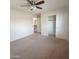 Bedroom featuring neutral carpet, ceiling fan, a walk-in closet, and door to the hallway at 15232 W Edgemont Ave, Goodyear, AZ 85395