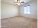 Spacious carpeted bedroom with ceiling fan and large window offering natural light at 15232 W Edgemont Ave, Goodyear, AZ 85395