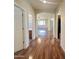 Hallway with wood floors leading to a brightly lit living area with a ceiling fan and arched doorways at 15232 W Edgemont Ave, Goodyear, AZ 85395