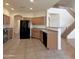 Kitchen area with tile flooring, light wood cabinets, and a black refrigerator and oven at 15232 W Edgemont Ave, Goodyear, AZ 85395