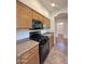 Kitchen showcasing wood cabinets, granite countertops, and a black gas range with a microwave above at 15232 W Edgemont Ave, Goodyear, AZ 85395