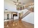 Open-concept living area with wood floors, staircase, and kitchen featuring dark appliances and light cabinets at 15232 W Edgemont Ave, Goodyear, AZ 85395