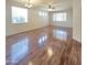 Spacious living room featuring wood floors, large windows, ceiling fan and neutral wall colors at 15232 W Edgemont Ave, Goodyear, AZ 85395